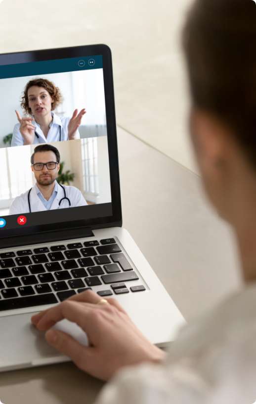 Ekran otwartego laptopa, na którym widać dwóch lekarzy biorących udział w spotkaniu online